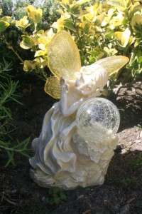 This beautiful fairy angel rests her head on a glass ball which lights 